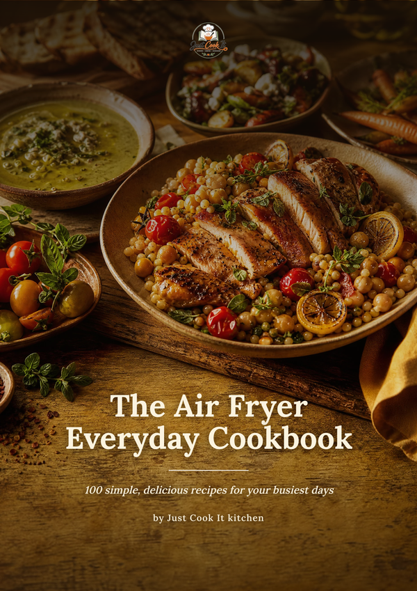 The front cover of the cookbook 'The Air Fryer Everyday Cookbook' by Just Cook It kitchen, featuring a warm, appetizing photograph of a cooked chicken salad with chickpeas, tomatoes, and lemon on a rustic wooden table.
