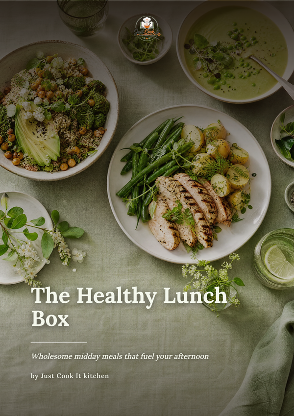 A styled overhead food scene showing several prepared lunch plates on a sage green tablecloth, including a salad, grilled chicken with asparagus and roasted vegetables, and bowls of soup. Large overlaid text reads 'The Healthy Lunch Box' with smaller subtitle and credit 'by Just Cook It kitchen'.